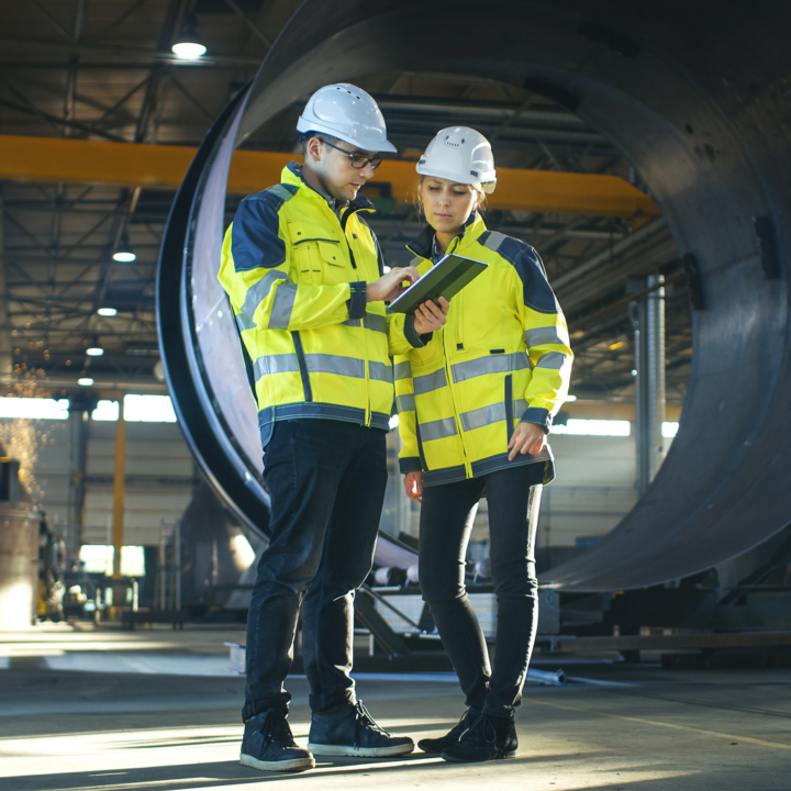 Kaksi työntekijää tarkastelevat tablettia työmaalla